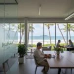 SafetyWing Avis 2026 : Assurance Santé Nomade Complète 1 Nomade numérique travaillant sur ordinateur dans un espace de coworking avec vue sur plage tropicale