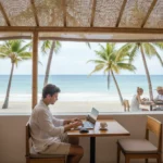 Gagner de l'Argent avec l'Affiliation Nomade : Guide 2026 1 Nomade numérique travaillant sur ordinateur portable dans un café en bord de mer, illustrant le travail en ligne
